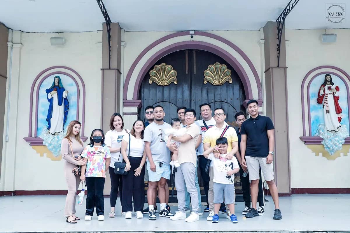 Families gathered for a group photo in front of the church doors after a baptism