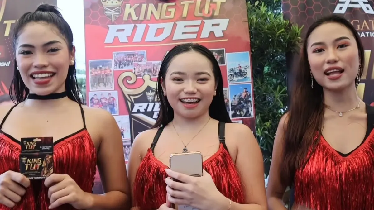 Three brand ambassadors in red fringe dresses presenting products at a brand event