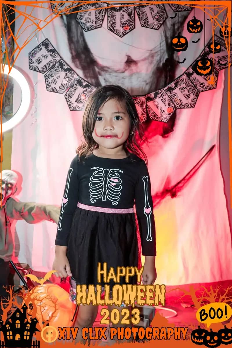 Young girl in a skeleton-print dress at a Halloween photo booth